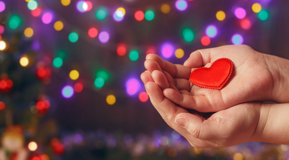 gift of the season with heart in hands stock photo